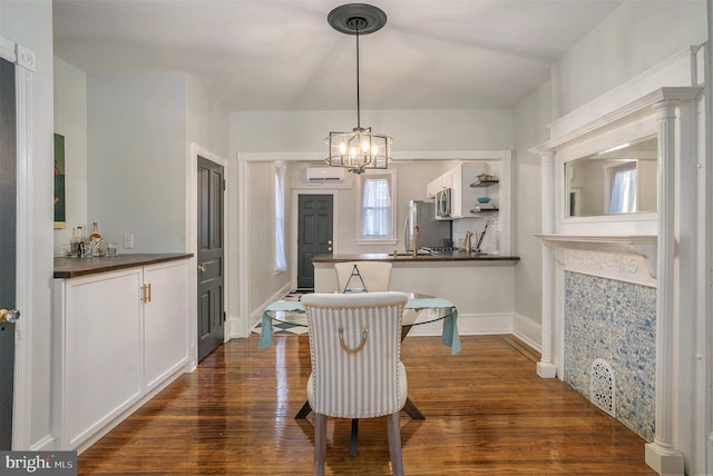 dining space with an inviting chandelier, dark wood-type flooring, and a wall unit AC