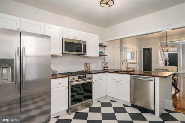 kitchen with white cabinetry, sink, decorative backsplash, and appliances with stainless steel finishes