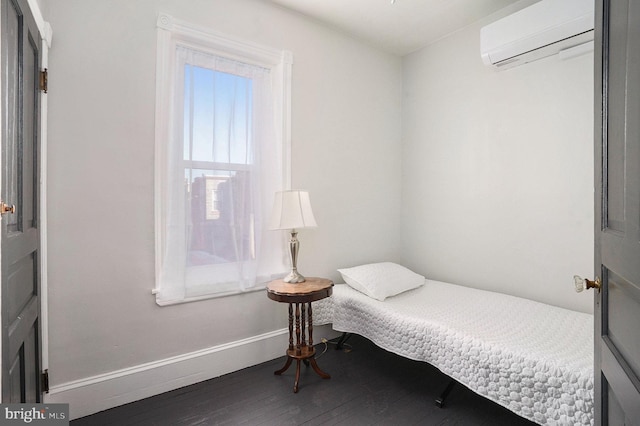 bedroom featuring wood-type flooring and a wall mounted AC