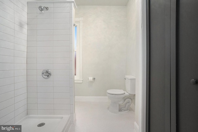 bathroom with a tile shower, tile patterned floors, and toilet