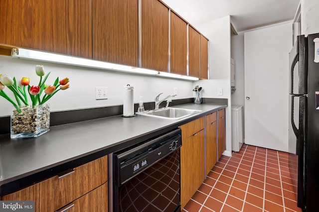 kitchen featuring dark tile patterned floors, sink, and black appliances