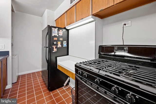 kitchen with dark tile patterned floors and black appliances