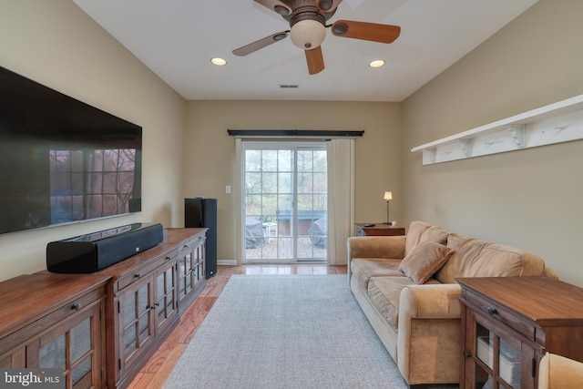 living room with ceiling fan and light hardwood / wood-style flooring