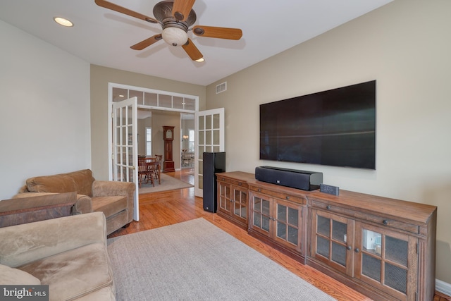 living room featuring light hardwood / wood-style floors, french doors, and ceiling fan