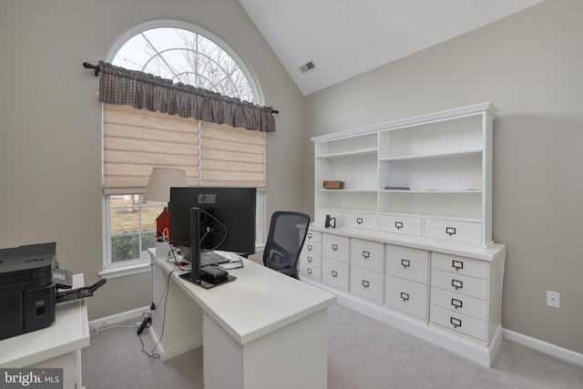 carpeted home office featuring vaulted ceiling