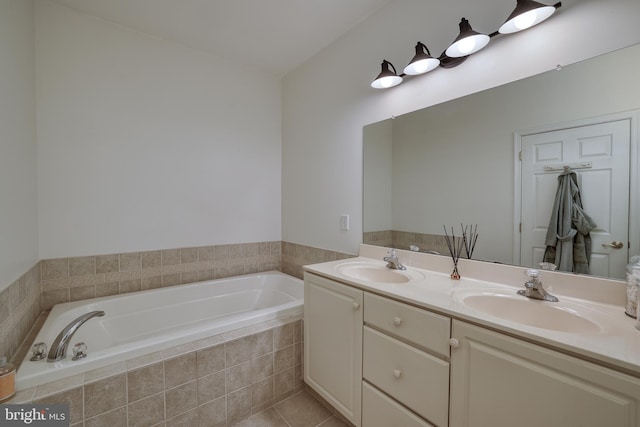 bathroom featuring tile patterned flooring, vanity, and a relaxing tiled tub