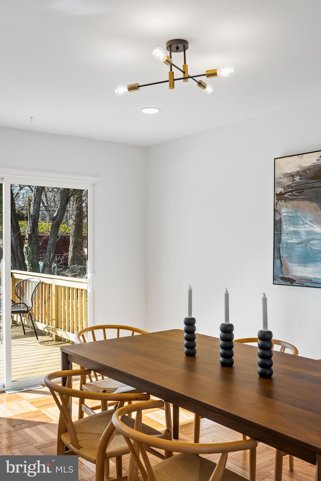 dining room with light parquet floors and a notable chandelier