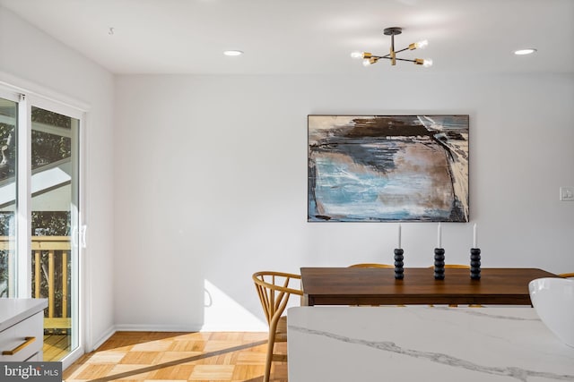 dining area with a chandelier and light parquet floors