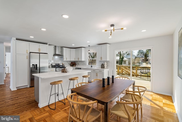 dining room with light parquet flooring, a chandelier, and sink