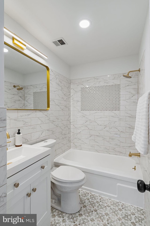 full bathroom featuring tile walls, tiled shower / bath combo, vanity, toilet, and tile patterned floors