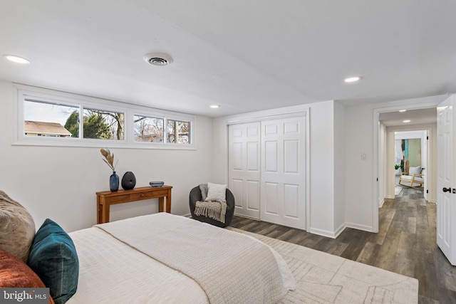 bedroom with dark hardwood / wood-style floors and a closet