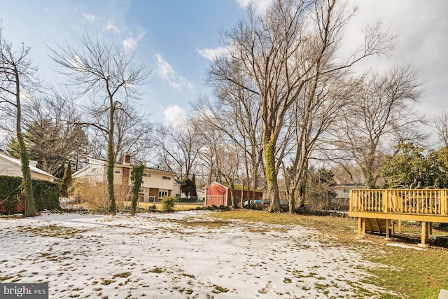 snowy yard featuring a deck