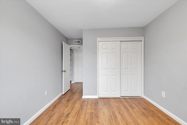 unfurnished bedroom featuring light hardwood / wood-style floors and a closet