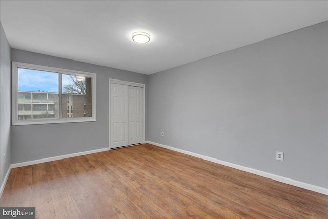 unfurnished bedroom with wood-type flooring and a closet