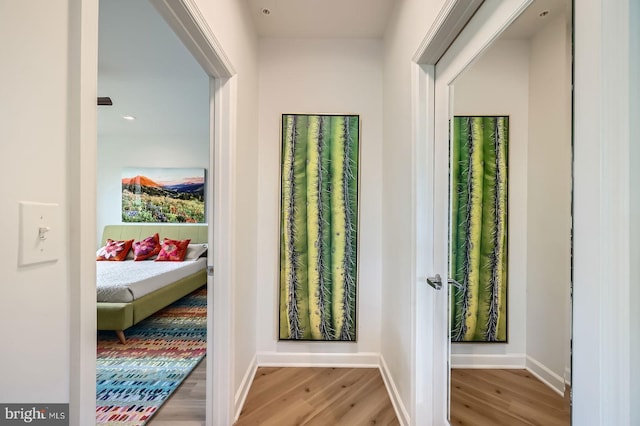 doorway featuring baseboards and wood finished floors