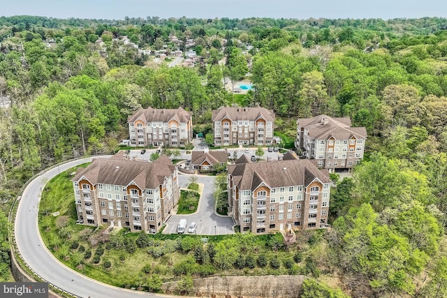 birds eye view of property featuring a forest view