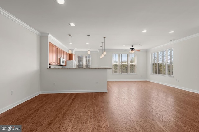 unfurnished living room with baseboards, ornamental molding, a ceiling fan, and wood finished floors