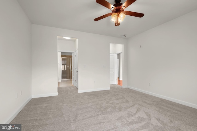 carpeted empty room featuring baseboards and a ceiling fan