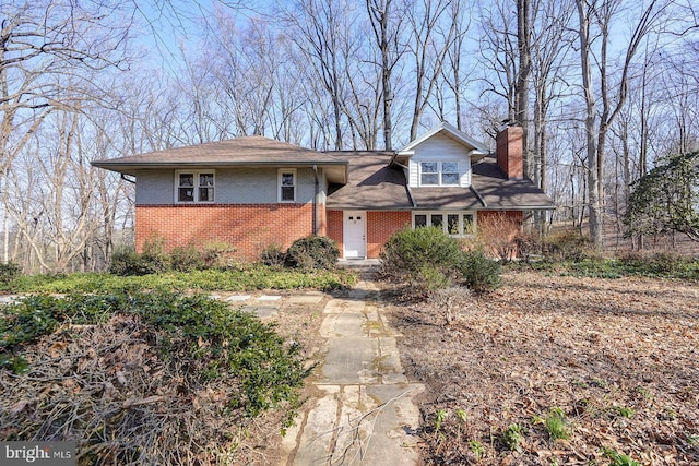 view of front of home with brick siding and a chimney