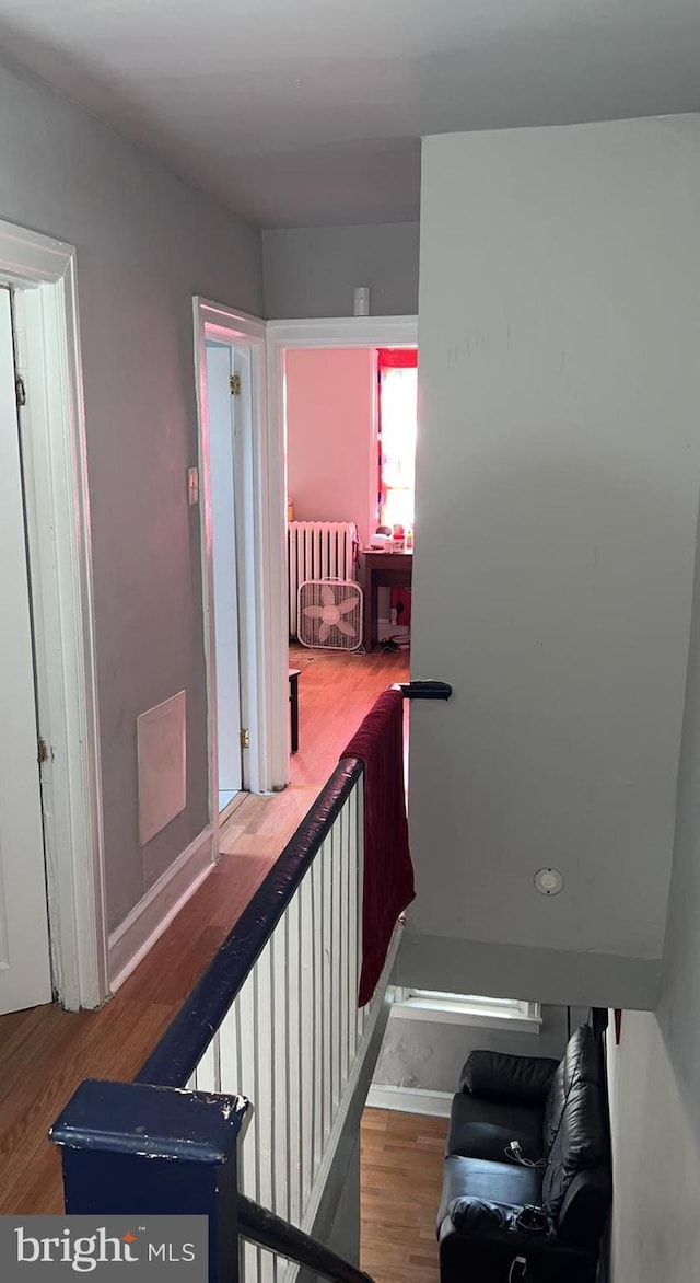 hall featuring radiator heating unit and hardwood / wood-style floors