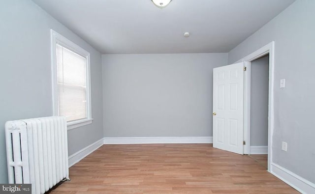 empty room featuring radiator and light wood-type flooring