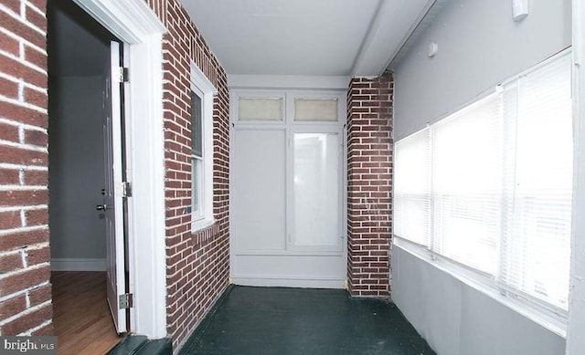 hallway featuring brick wall