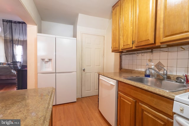 kitchen with sink, light wood-type flooring, stainless steel dishwasher, decorative backsplash, and stove