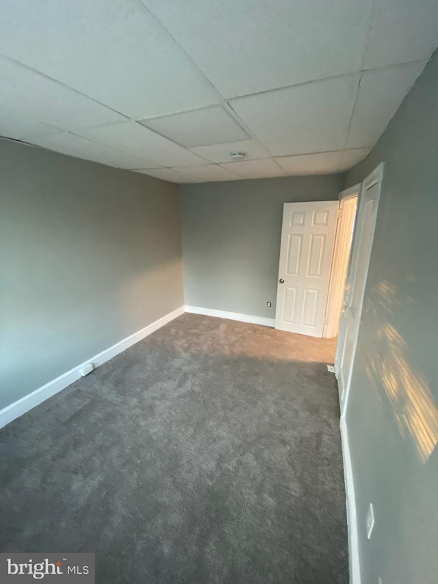 carpeted empty room with a drop ceiling