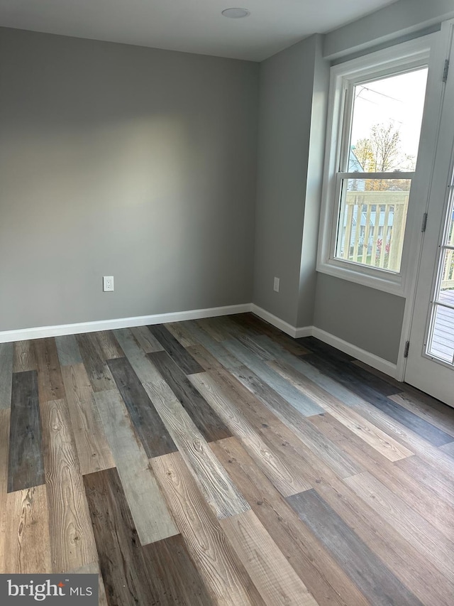 unfurnished room with baseboards and wood finished floors