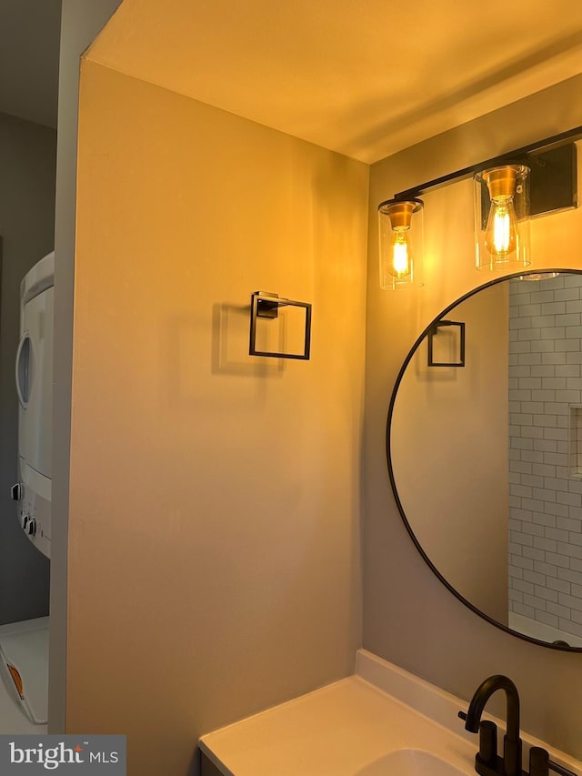 bathroom with vanity and stacked washer and clothes dryer