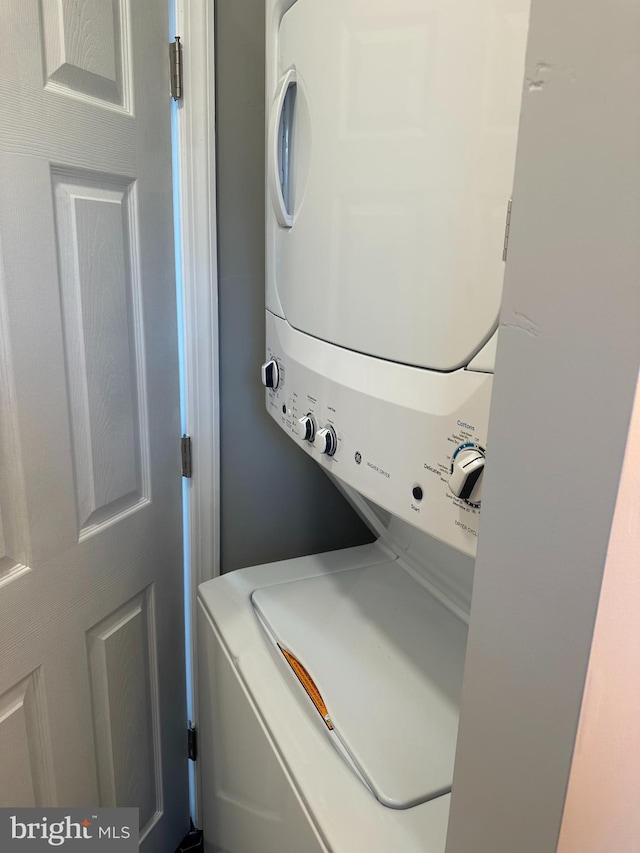 washroom with stacked washer and dryer and laundry area