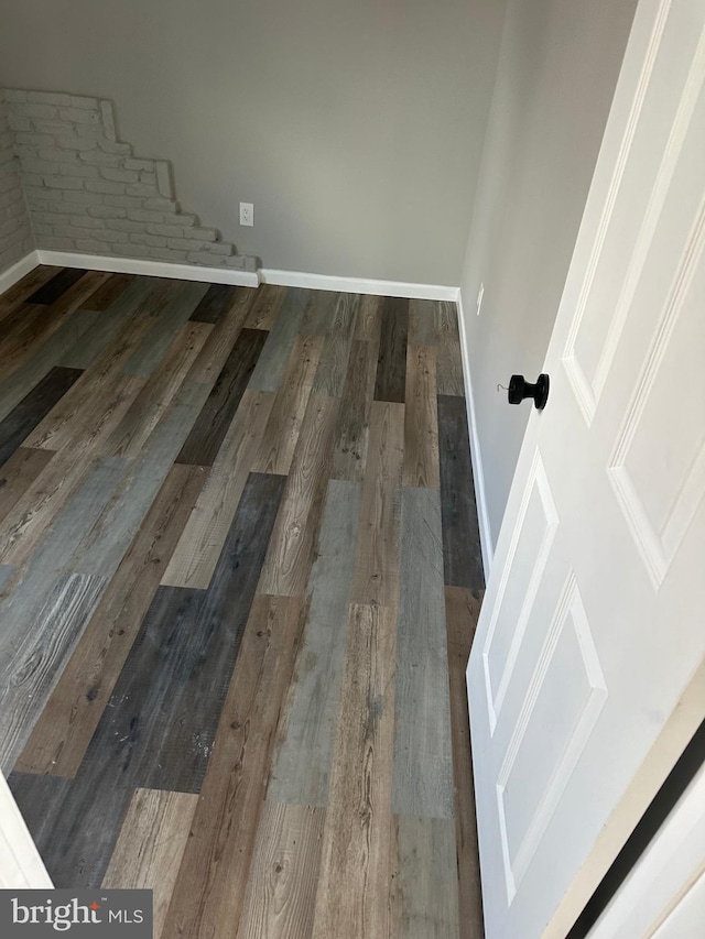 interior space featuring baseboards and wood finished floors