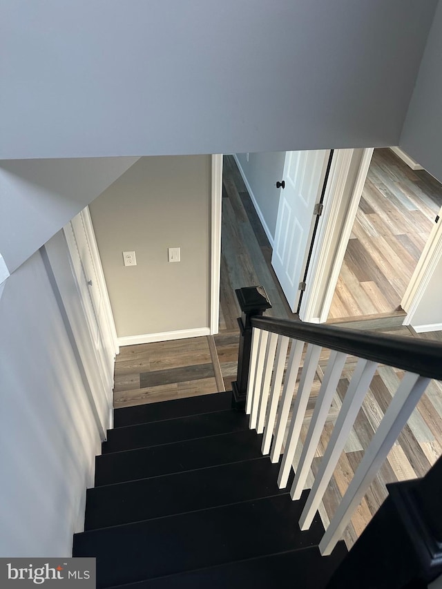 stairs featuring baseboards and wood finished floors