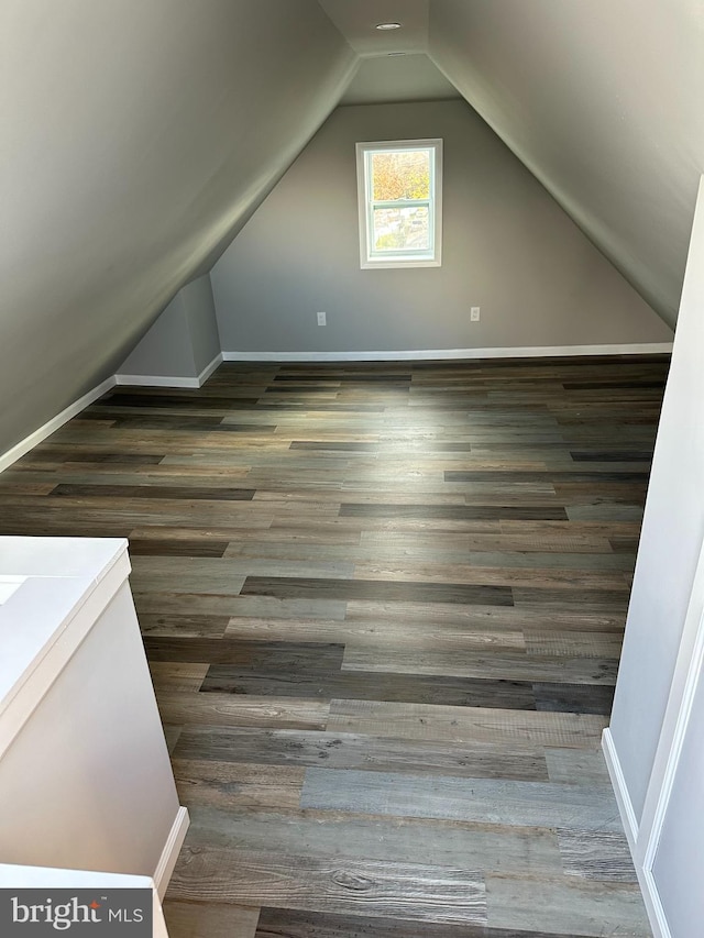 bonus room with vaulted ceiling, wood finished floors, and baseboards