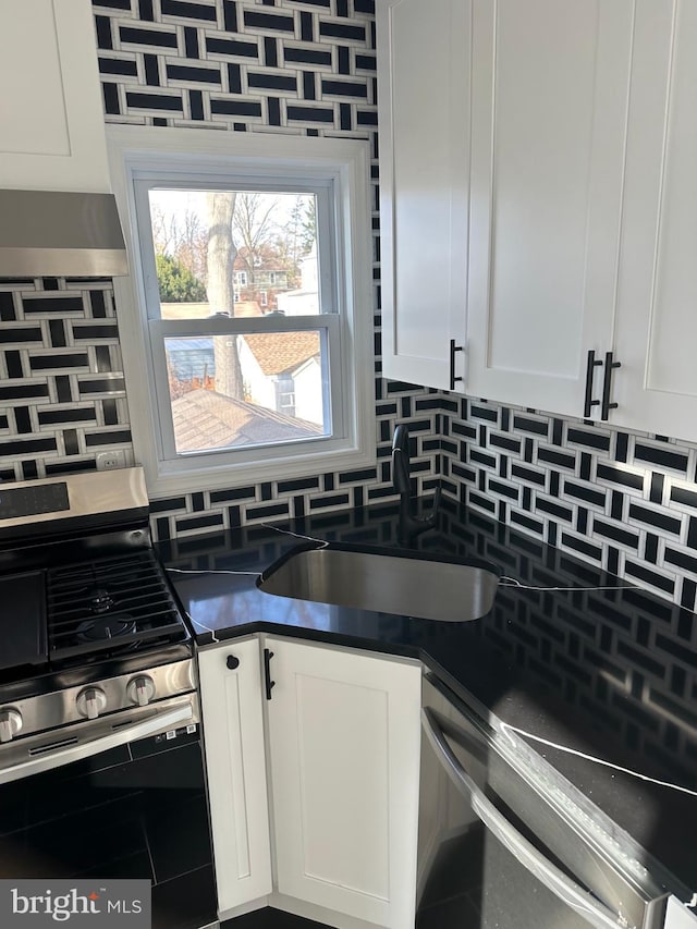 kitchen featuring sink, white cabinetry, stainless steel range with gas stovetop, dishwasher, and decorative backsplash