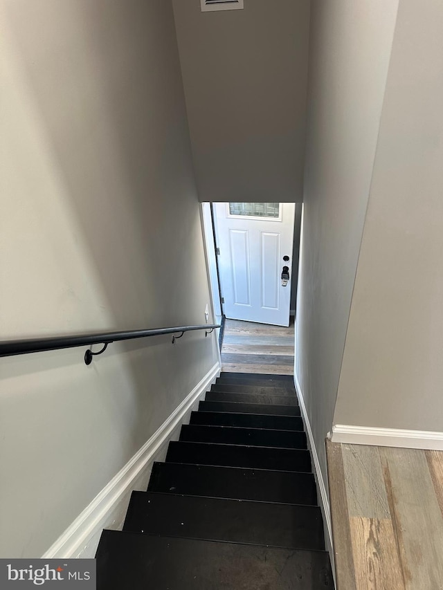 stairway featuring baseboards and wood finished floors