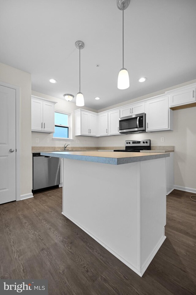 4 Landing Pl Unit 4, York, PA 17408 - kitchen with appliances with stainless steel finishes, decorative light fixtures, white cabinetry, dark hardwood / wood-style flooring, and a center island