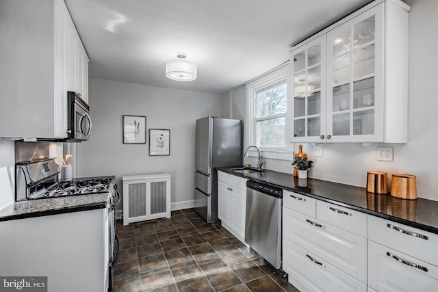 kitchen with white cabinetry, stainless steel appliances, radiator, and sink