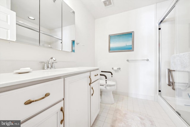 bathroom with vanity, tile patterned flooring, a shower with shower door, and toilet