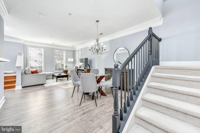 dining space with a notable chandelier, crown molding, and wood-type flooring