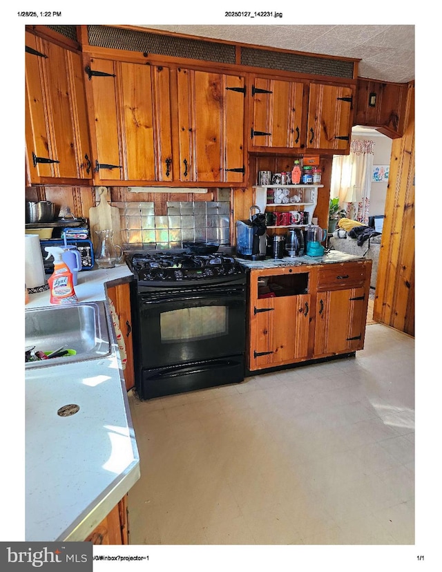 kitchen featuring black gas range oven and sink