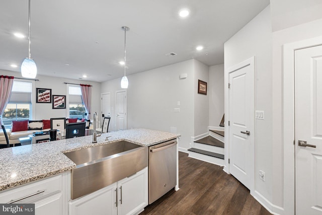 kitchen featuring pendant lighting, light stone countertops, stainless steel dishwasher, and white cabinets