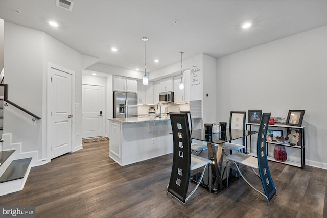 dining area with dark hardwood / wood-style floors and sink