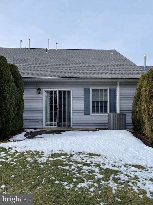 snow covered back of property featuring french doors