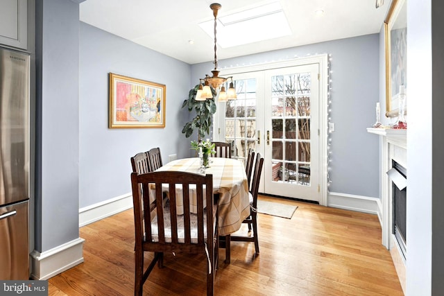 dining area with light wood-type flooring and french doors