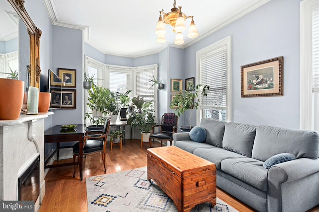 living room with hardwood / wood-style flooring, ornamental molding, and a notable chandelier