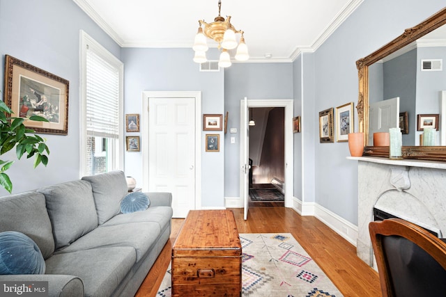 living room with hardwood / wood-style floors, crown molding, and a chandelier