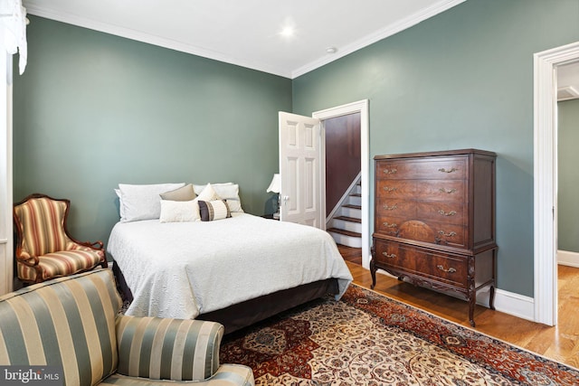 bedroom with hardwood / wood-style floors and ornamental molding