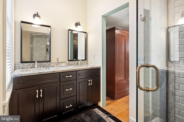 bathroom featuring vanity, wood-type flooring, and a shower with door