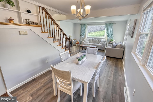 dining area with an inviting chandelier, a baseboard heating unit, and dark wood-type flooring